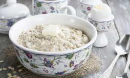 Porridge with butter and eggs on the wooden table