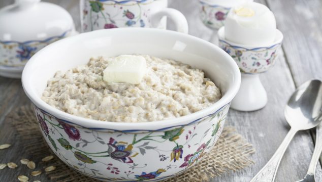 Porridge with butter and eggs on the wooden table